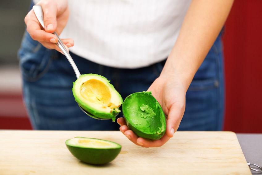 41394850 - young woman making salad in the kitchen - peeling avocado